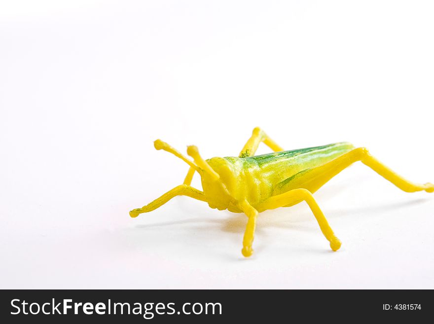 Single grasshopper toy figure macro close up on the white background
