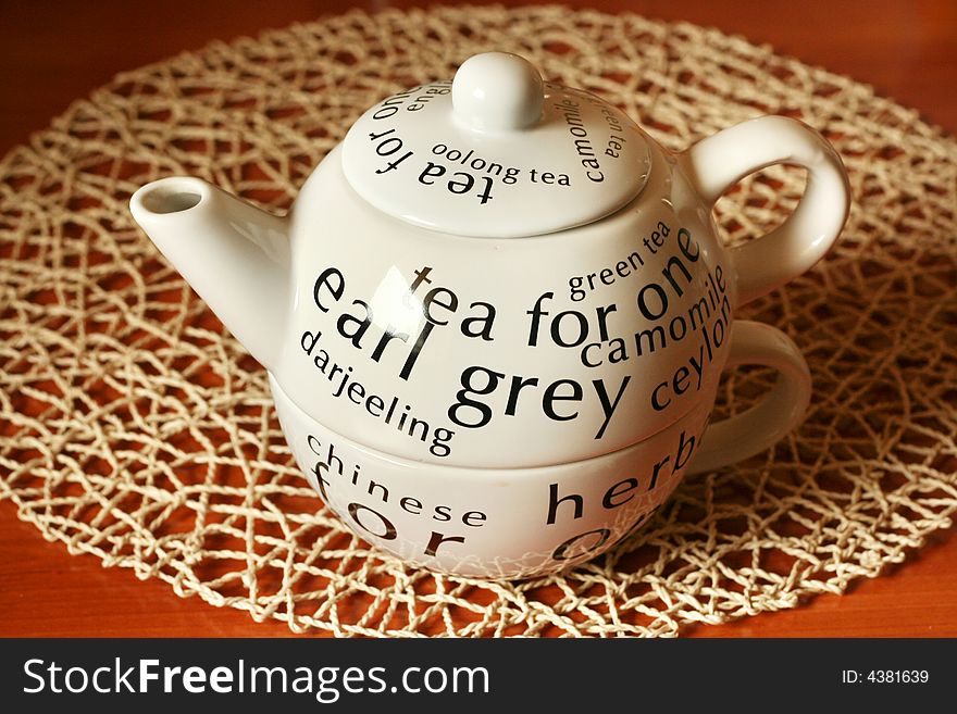 White teapot on a brown wooden table