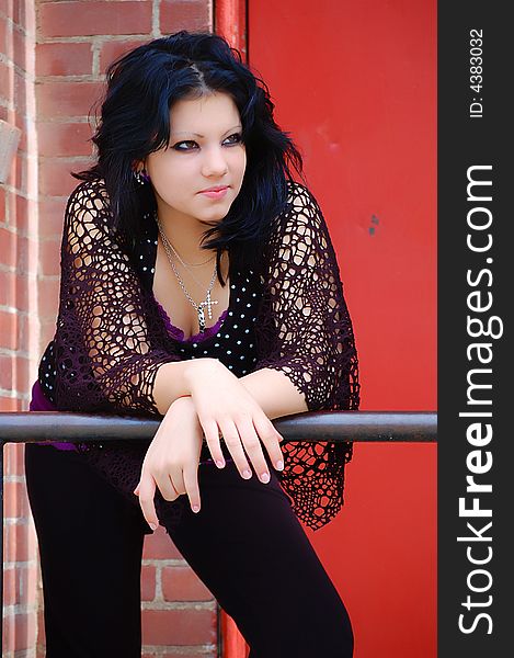 Long Black Hair Female Black Clothing standing against railing. Long Black Hair Female Black Clothing standing against railing