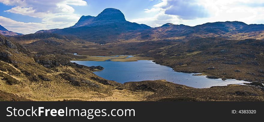 Mount Sulven with a small loch in the foreground in the Asynt region of the western highland of Scotland. Mount Sulven with a small loch in the foreground in the Asynt region of the western highland of Scotland
