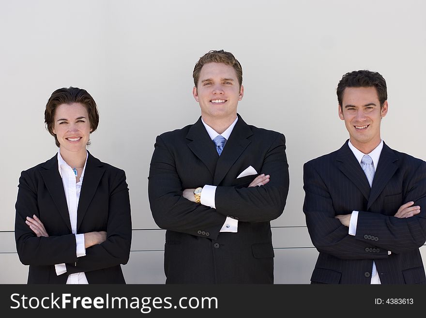 Three business people standing in a row looking at camera. Three business people standing in a row looking at camera.