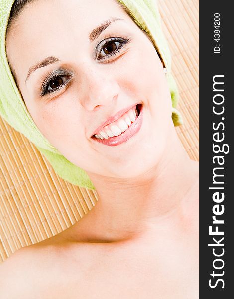 Attractive woman on Bamboomat smiling to you. Closeup on Face and collarbone. Vertical. Attractive woman on Bamboomat smiling to you. Closeup on Face and collarbone. Vertical.