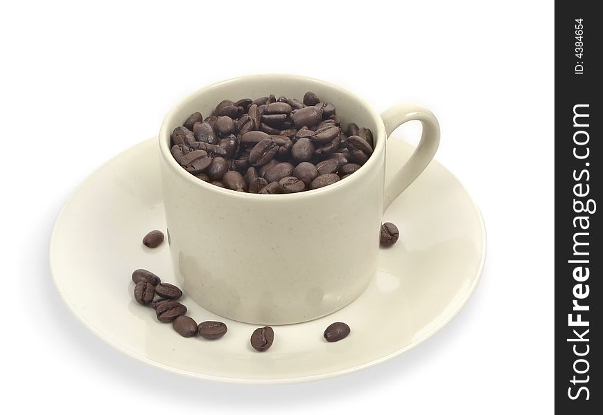 Coffee beans in creme cup with a few coffee beans on saucer. Coffee beans in creme cup with a few coffee beans on saucer.