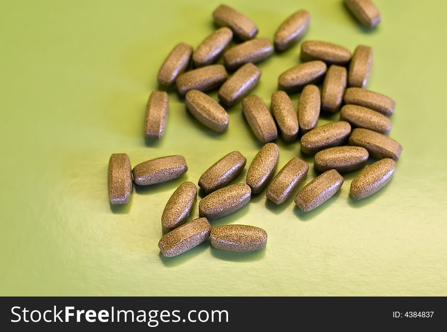 Brown pills on green background. Brown pills on green background