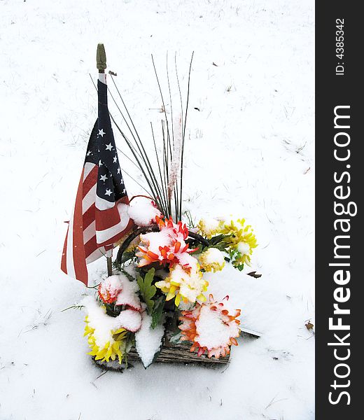 Snow was falling on a cemetery bouquet