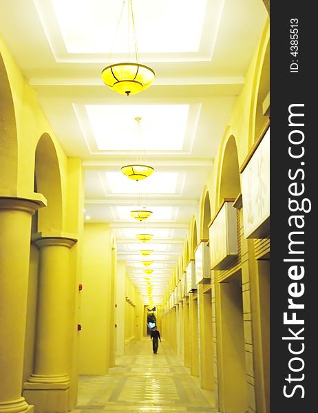 A long corridor of an apartment block , files of coloumns,pendant lamps. A long corridor of an apartment block , files of coloumns,pendant lamps