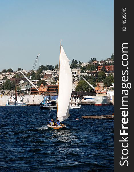 Sailboat on the water backdropped by city dweller homes