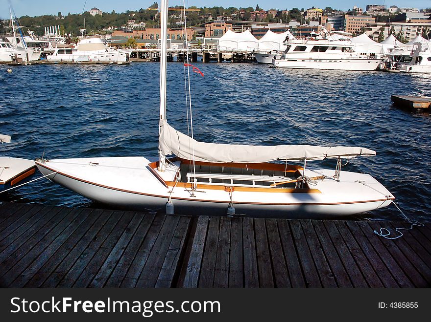 Sailboat on the water backdropped by city dweller homes