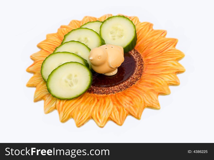 Cucumber slices and salt-cellar on a flower-shaped plate