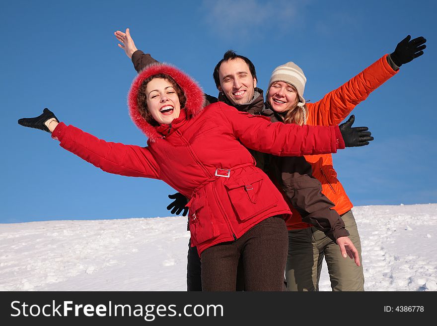 Group of friends move by hands in winter on hillside