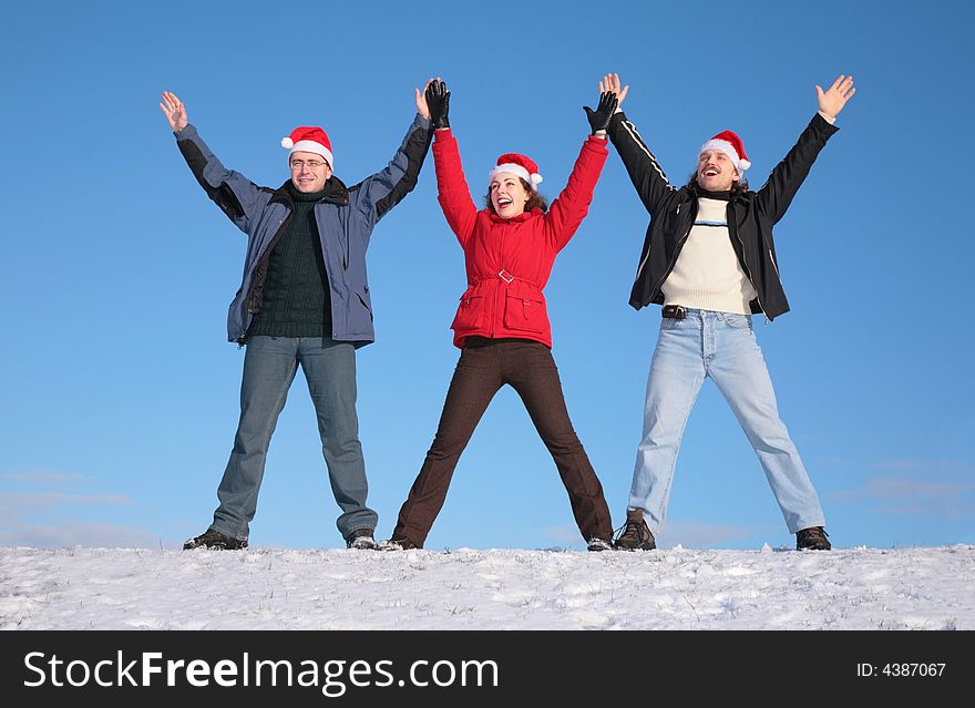 Three friends greetings on snow  in santa claus hats. Three friends greetings on snow  in santa claus hats