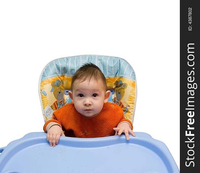 The small child sits at a children's little table on a white background. The small child sits at a children's little table on a white background