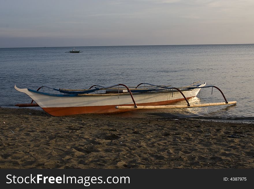 Small Banca boat at sunset on Beach