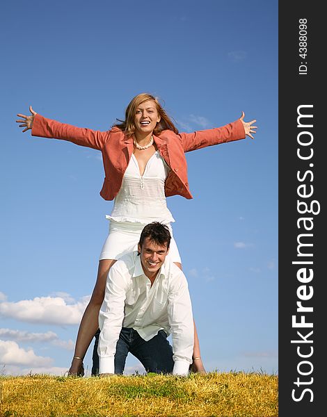 Couple on meadow on sky background