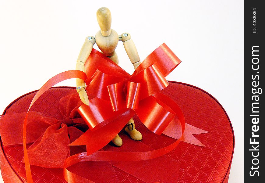 An artists model wrapping a box with ribbons and bows