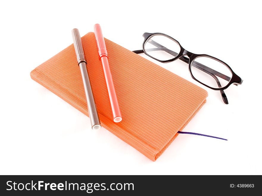 Red book, black glasses and markers isolated on a white background