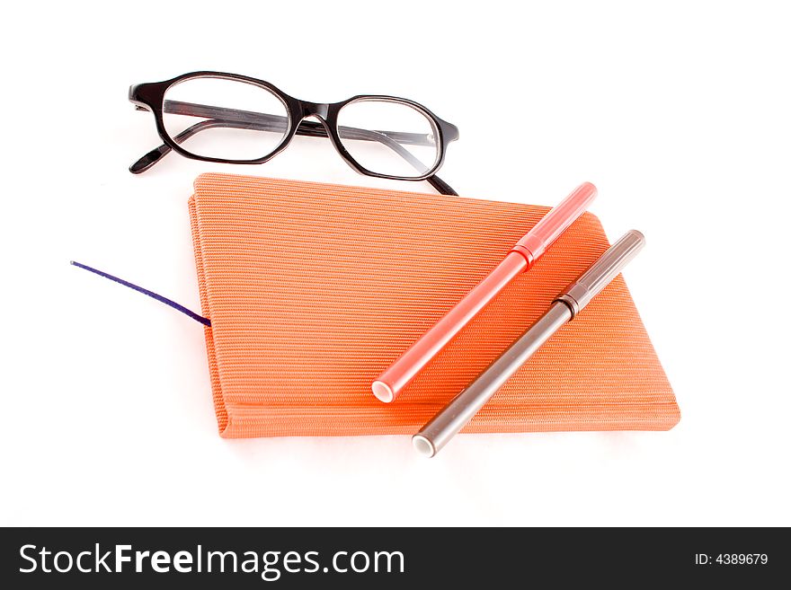 Red book, black glasses and markers isolated on a white background