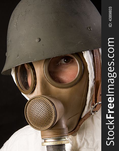Woman in gas mask and helmet on black background