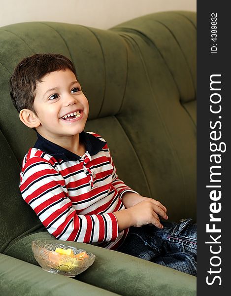 Little boy laughing sitting on sofa
