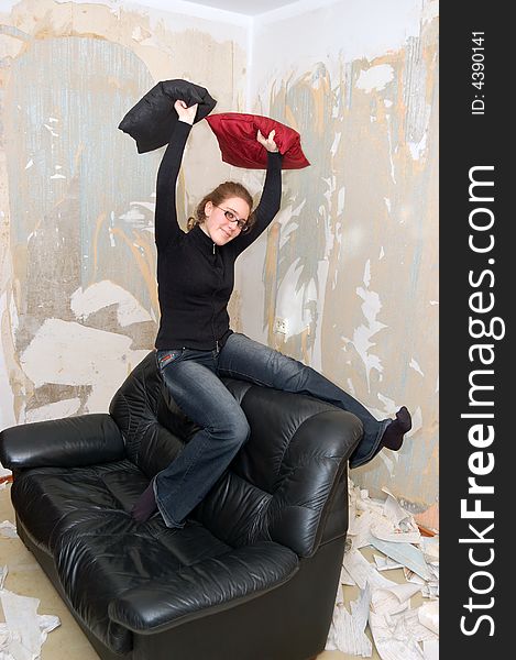 Beautiful young girl on a sofa in the empty room