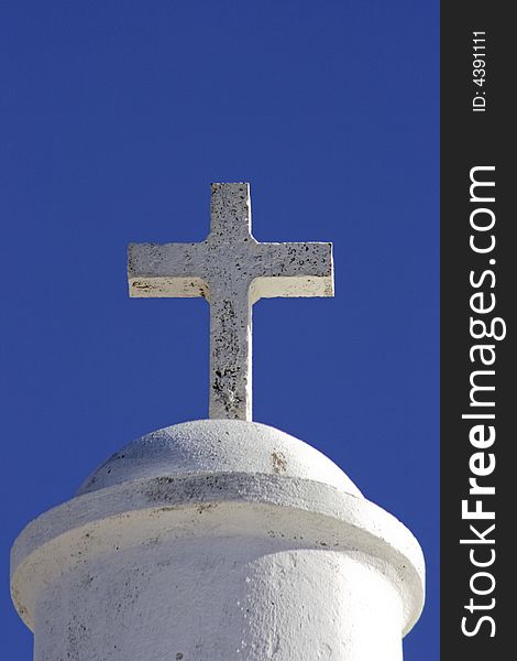 White cross on a chapel against a blue sky in Portugal