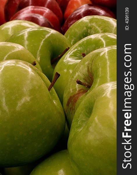 Macro of granny smith apples with red delicious apple background
