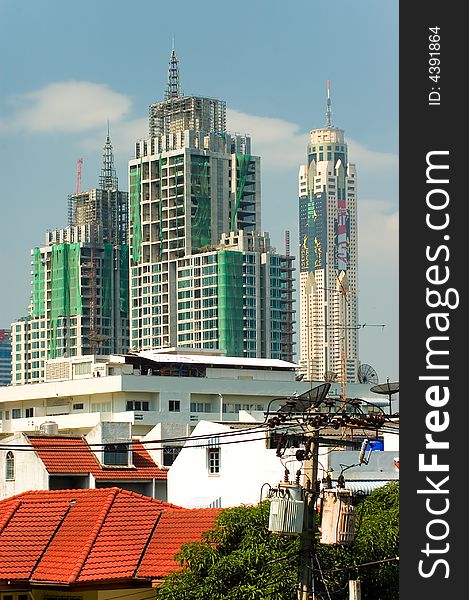 Tall skyscrapers in bangkok against blue sky