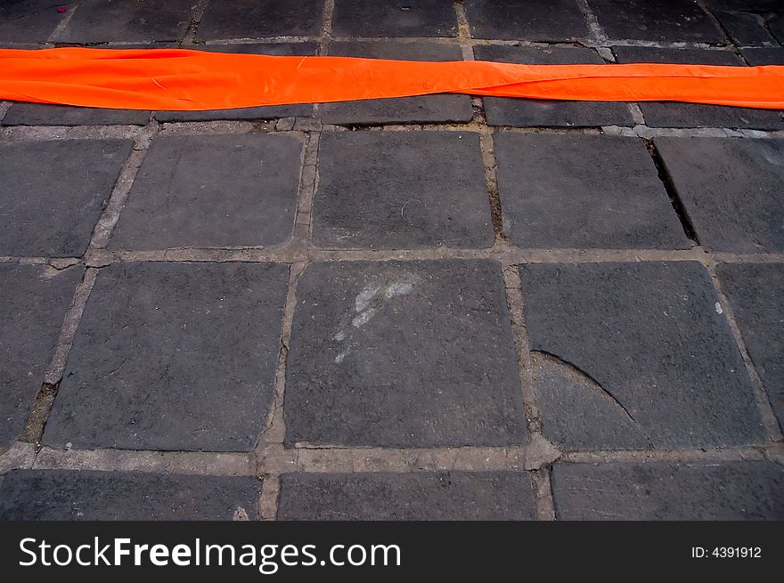 A thread of orange monks robe lying on the ground. A thread of orange monks robe lying on the ground