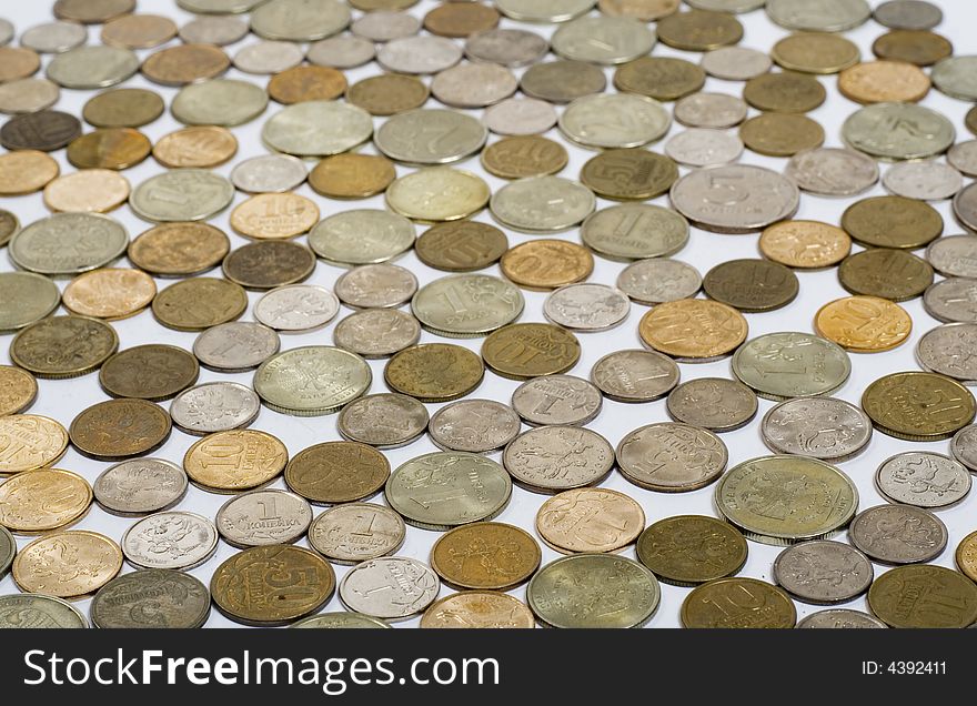 Field of coins on white background, focus on foreground of image