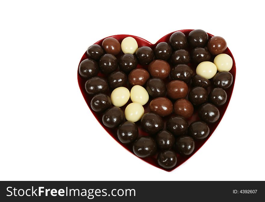 Heart and chocolate candies on white