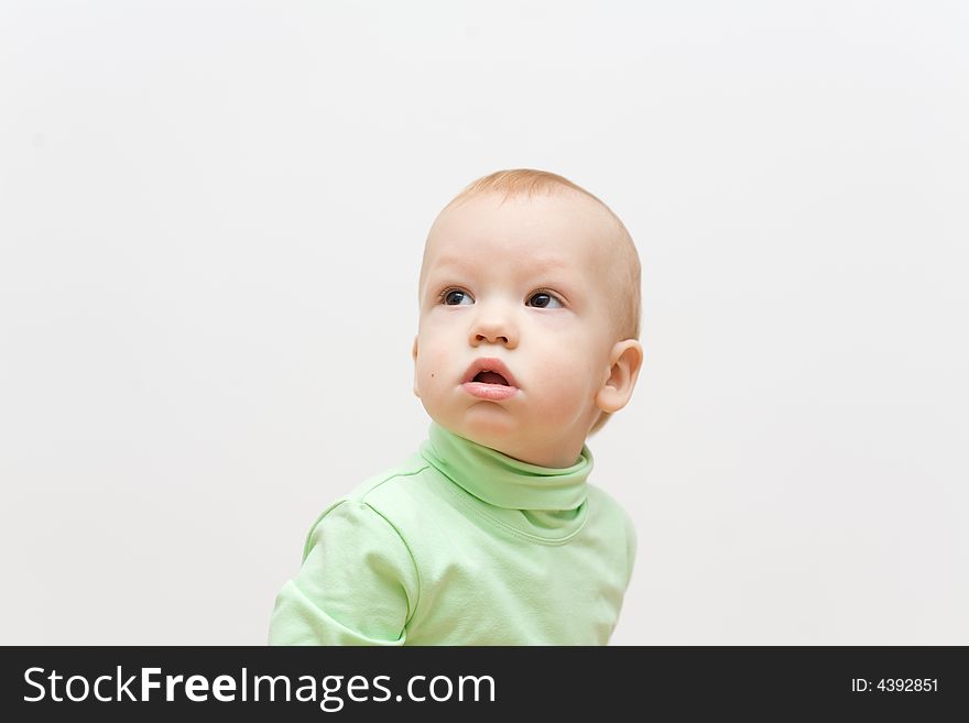 Little boy with interest look at left corner of image. Over light gray background