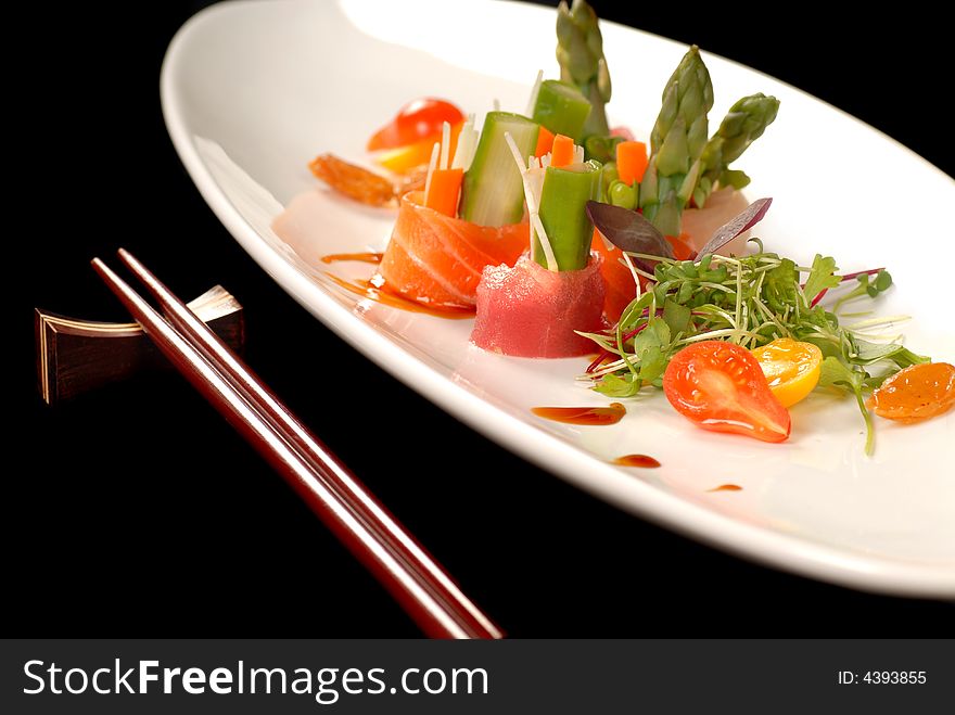 Sashimi on a white plate with chop sticks