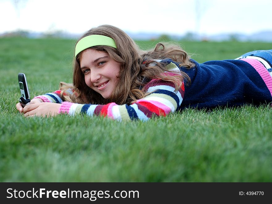 Young blond girl in the park and cell phone. Young blond girl in the park and cell phone