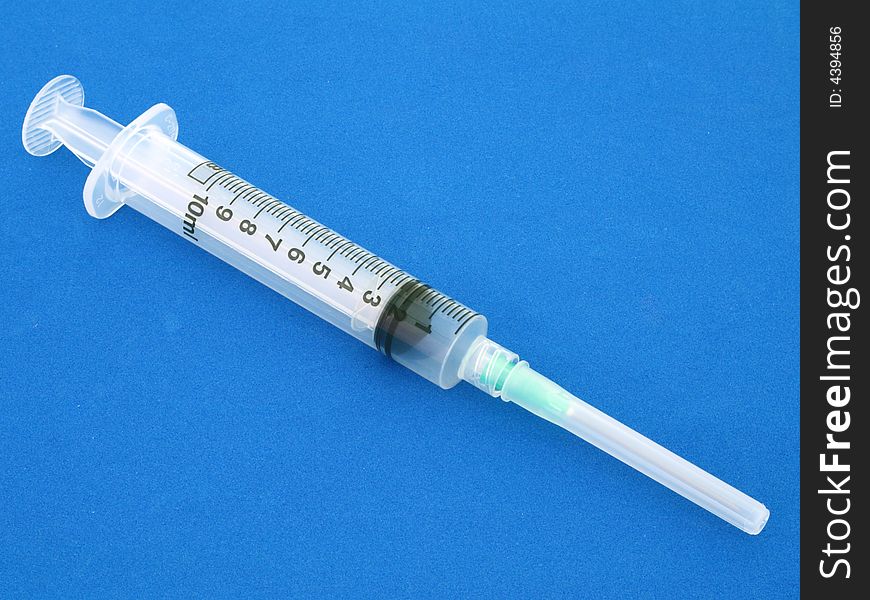 Syringe over a blue surface