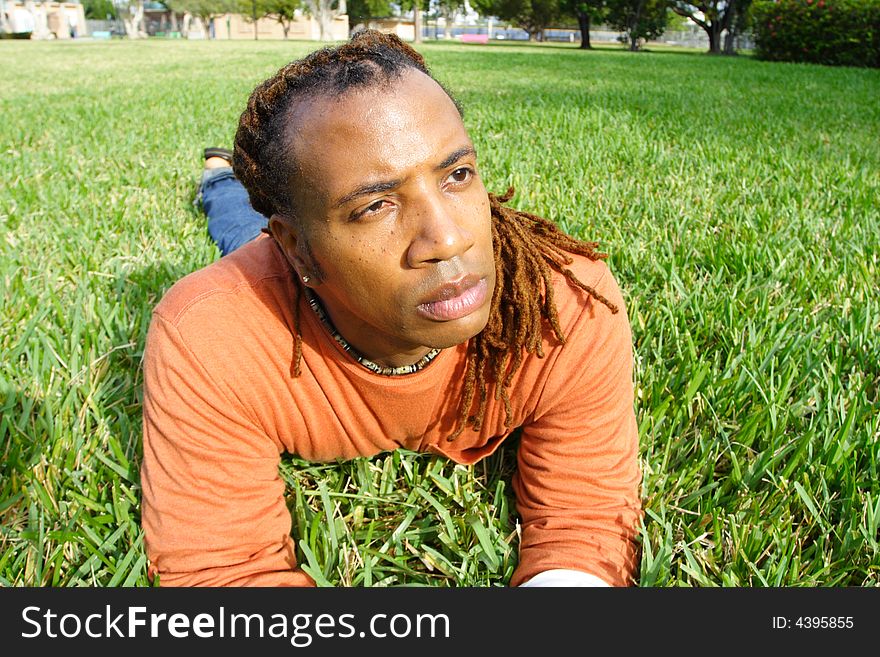Man lying on the grass looking at something. Man lying on the grass looking at something