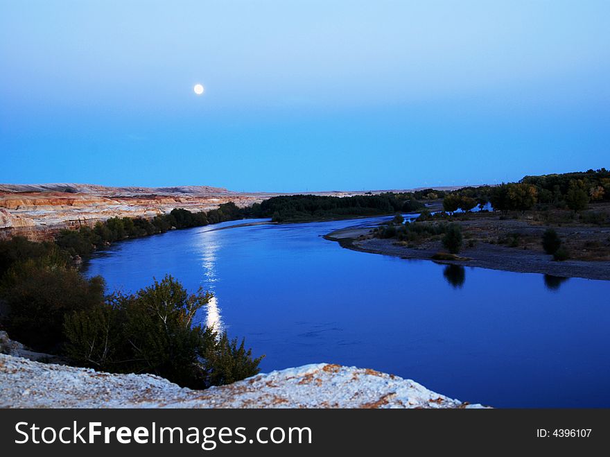 3 moons one on the sky one in the water and one, just the river, looks like a moon