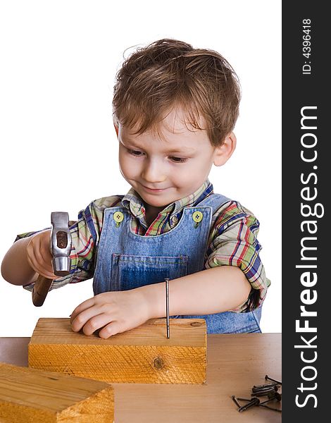 Child hammers a hammer in nails