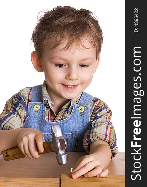 Child hammers a hammer in nails