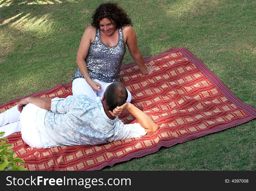Man and woman on a rug in the park. Man and woman on a rug in the park
