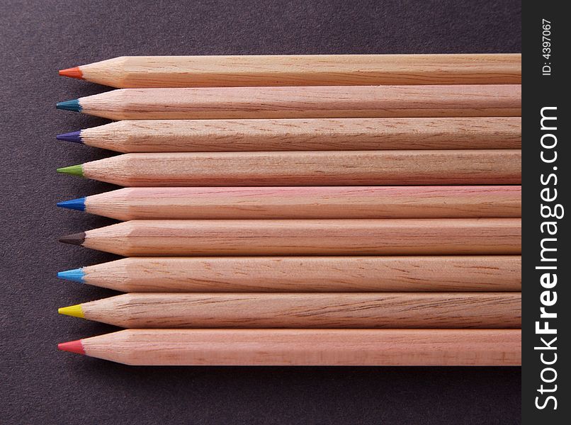 Coloured Crayons in a neat row against black background