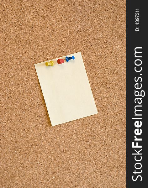 Blank page on corkboard with pins
