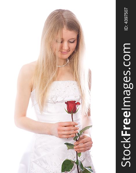 Young smiling bride look to red rose in her hands