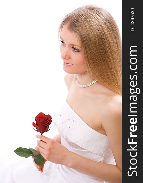 Young bride with rose in hands sit on floor