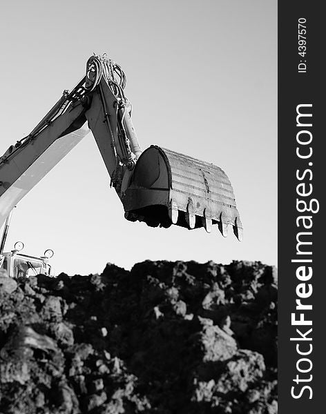 Hydraulic excavator at work. Shovel bucket against sky