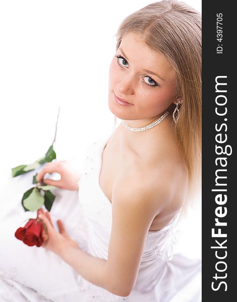 Young smiling bride with rose in hands sit and look to camera