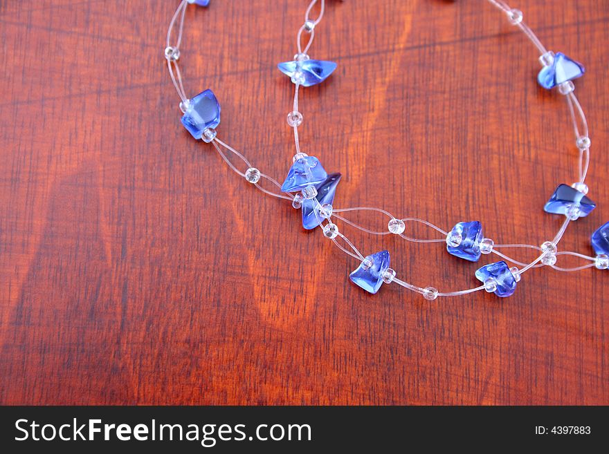 Blue string jewelery on a brown wooden background. Blue string jewelery on a brown wooden background