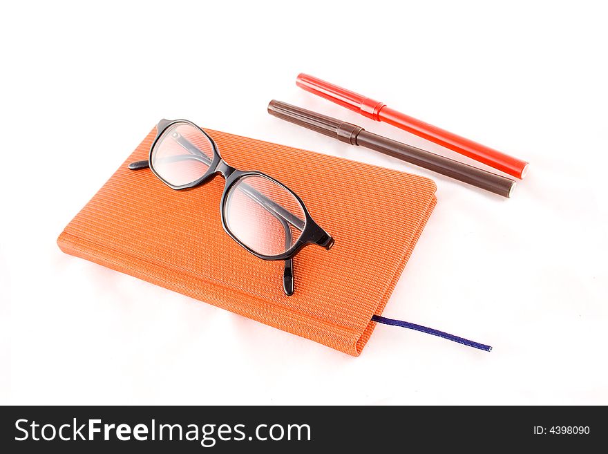 Red book, black glasses and markers isolated on a white background. Red book, black glasses and markers isolated on a white background