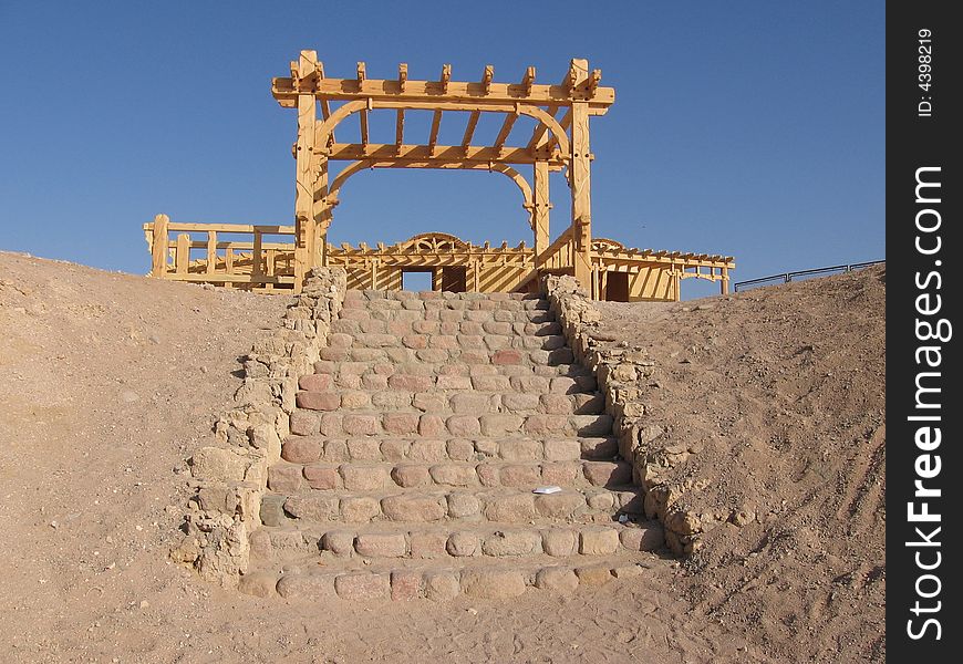 A rock stair in red sea, with a wood brown building