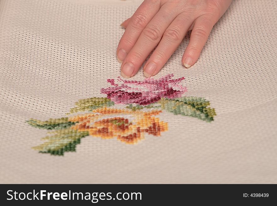 Woman embroidering a beautiful pink rose. Woman embroidering a beautiful pink rose
