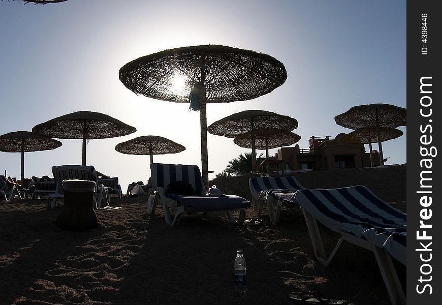 A beautiful sunset from a red sea beach, with sun hidden with big umbrella. A beautiful sunset from a red sea beach, with sun hidden with big umbrella